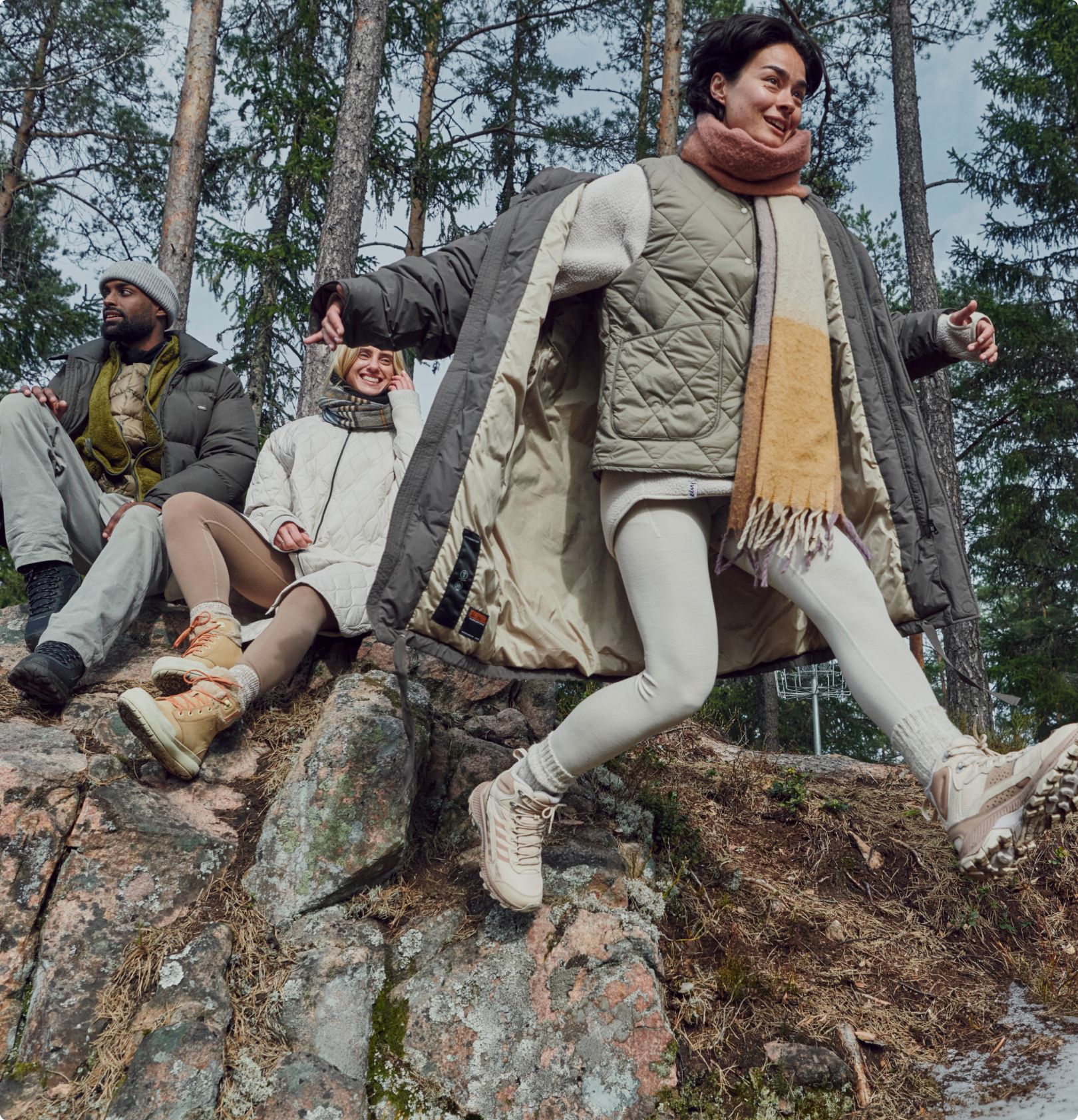 Una persona con botas Merrell que salta de una gran roca.